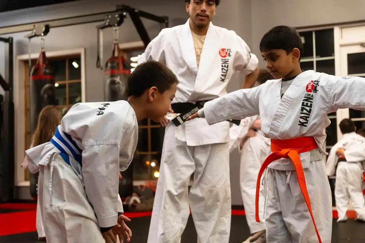 An instructor adjusting a child's stance during a class