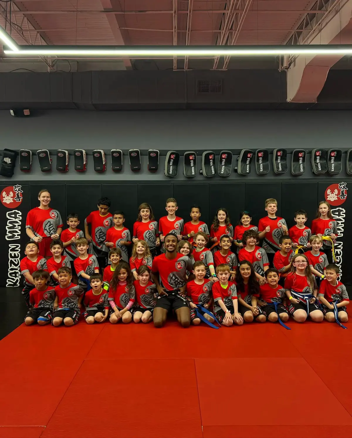 A large group of children sitting together on the training mats